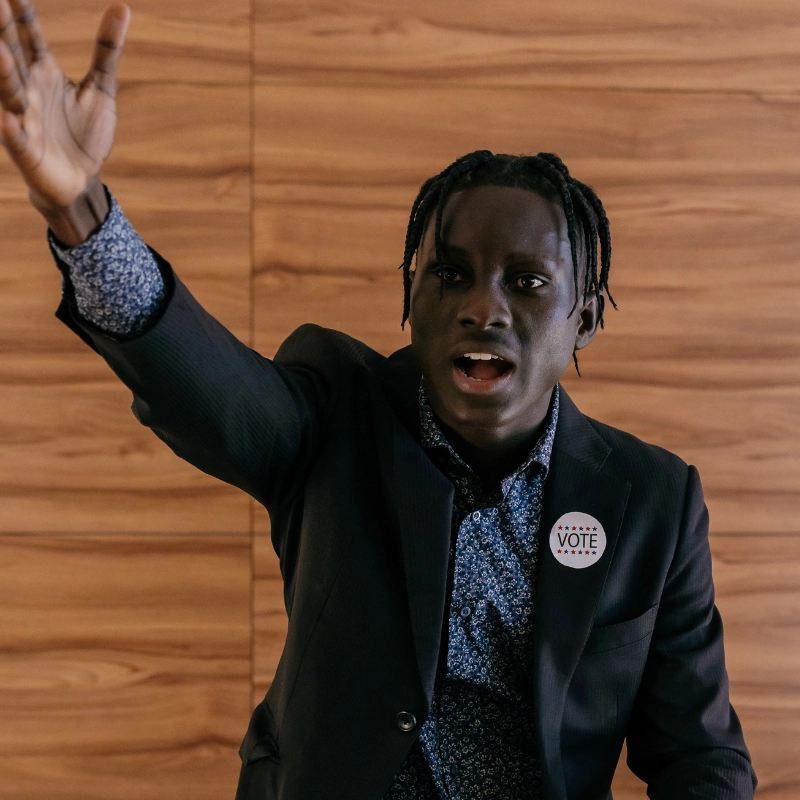 Junger Redner mit ausdrucksstarker Körpersprache hält eine emotionale Rede – Rhetoriktraining für Ausdruck und Überzeugungskraft.