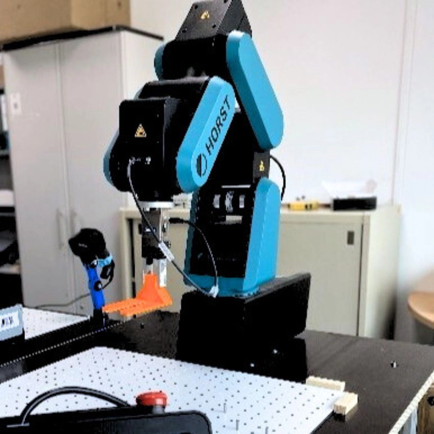 Roboterarm vom Typ HORST bestückt mit Endeffektor gezielt Bauteile auf einer Arbeitsfläche.