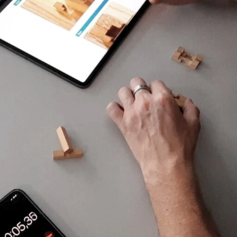 Hand baut Holzelemente nach digitaler Anleitung auf einem Tablet im Industrie 4.0 Lernmodul.