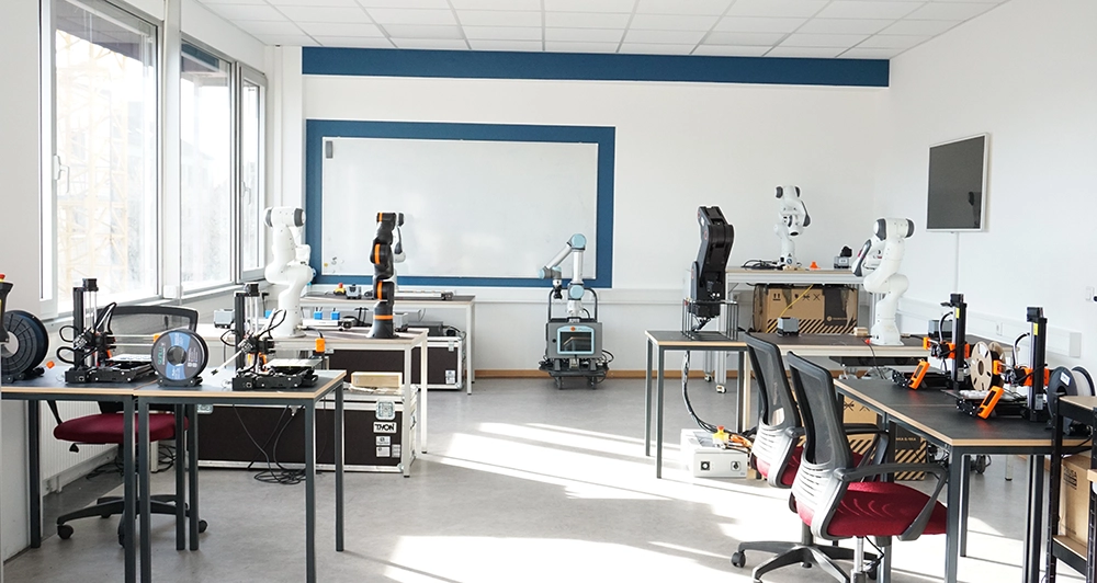 Hochmoderner Schulungsraum mit kollaborativen Robotern, 3D-Druckern und Industrie 4.0 Ausrüstung für digitale Weiterbildung.