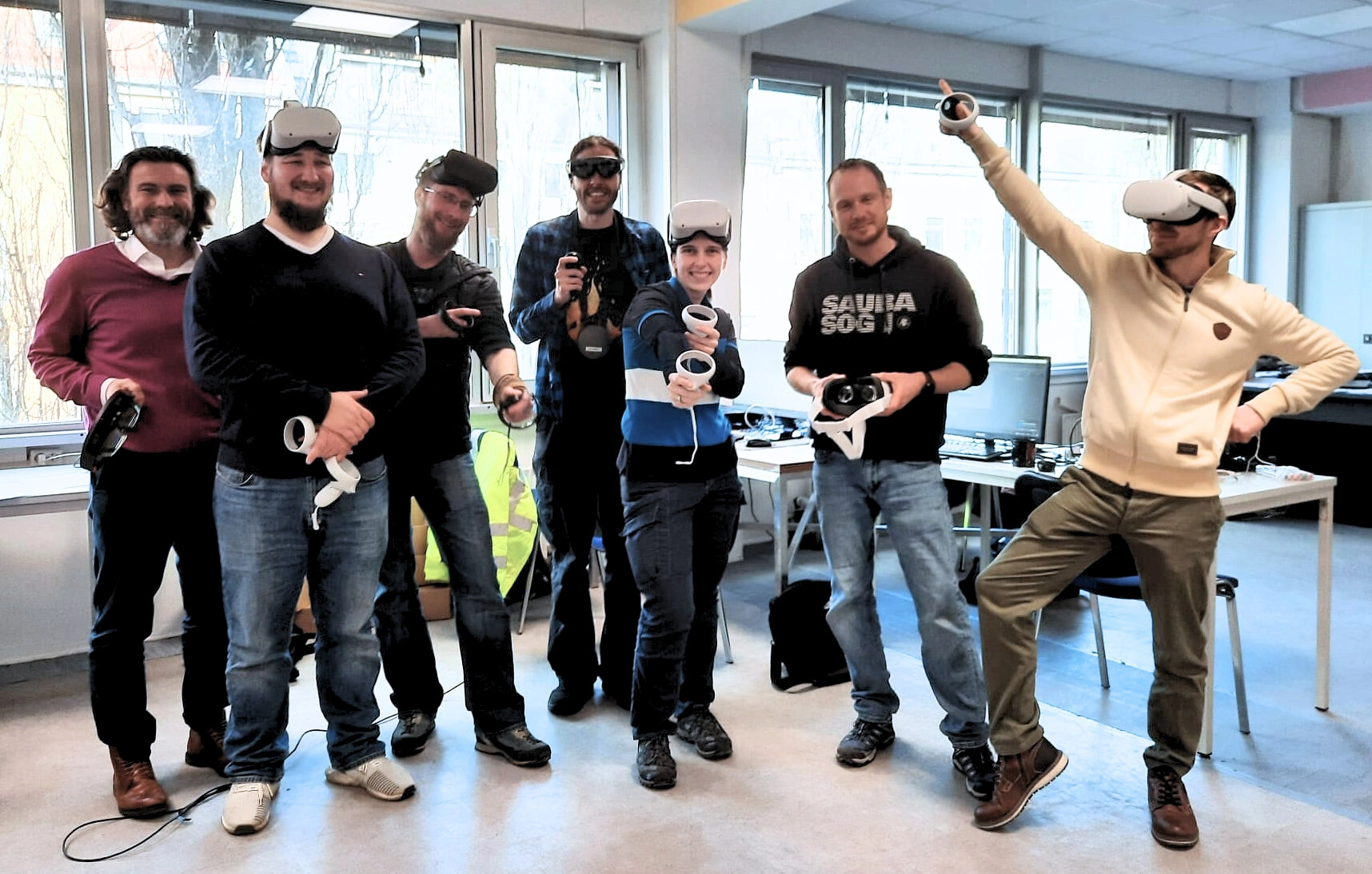 Team von Mitarbeitenden testet VR-Brillen in Schulungsraum – moderne Weiterbildung mit Gamification und Technologieeinsatz.